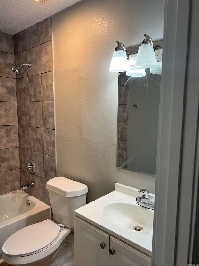 full bathroom with vanity, a textured ceiling, toilet, and tiled shower / bath combo