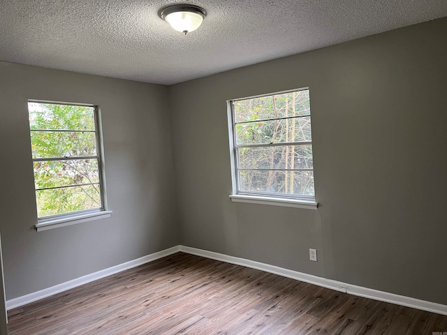 empty room with a textured ceiling and hardwood / wood-style flooring