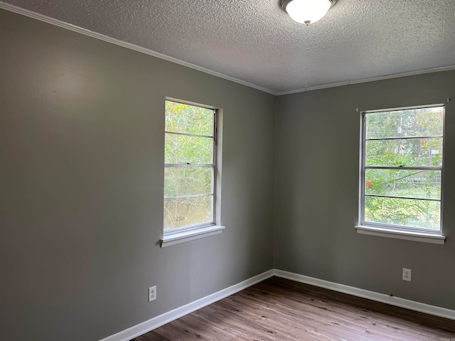 unfurnished room featuring a textured ceiling, hardwood / wood-style floors, ornamental molding, and plenty of natural light