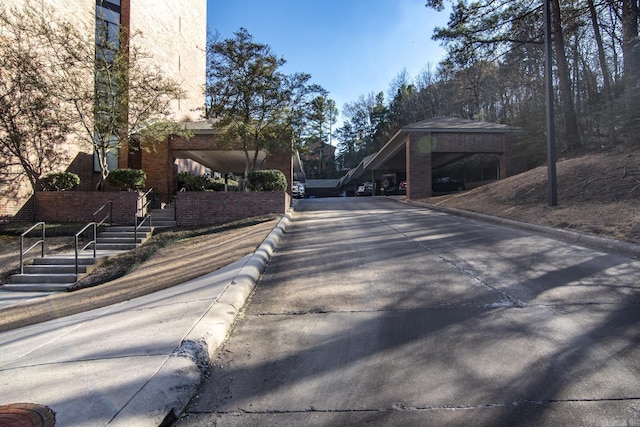 view of street featuring concrete driveway and curbs