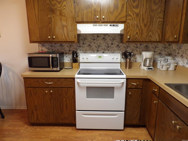 kitchen featuring sink, light hardwood / wood-style flooring, and white electric stove