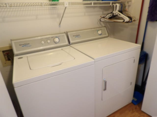 laundry room featuring hardwood / wood-style flooring and washing machine and dryer