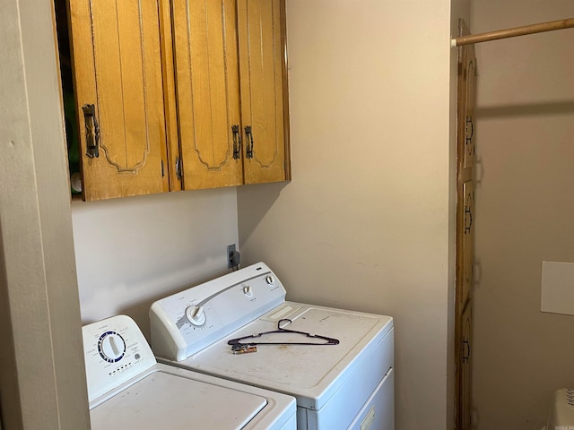 washroom with cabinets and washing machine and clothes dryer