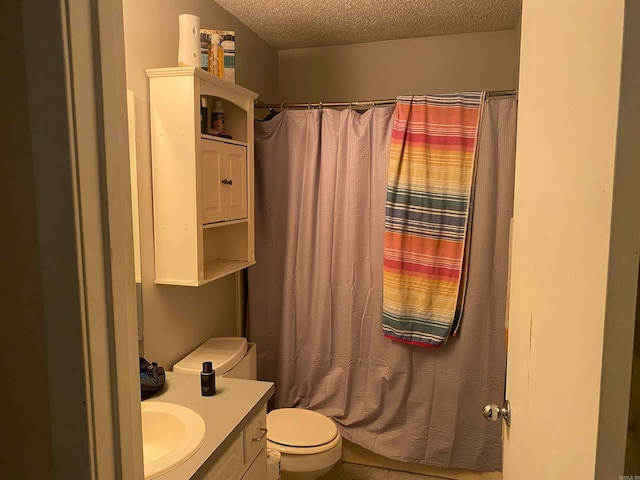 bathroom featuring vanity, a textured ceiling, and toilet