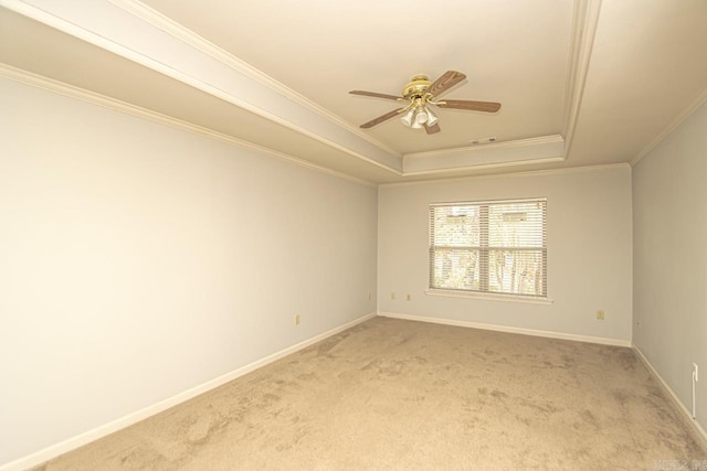 spare room with carpet, ceiling fan, crown molding, and a tray ceiling