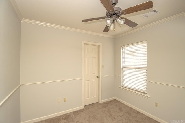 carpeted spare room with ceiling fan and crown molding