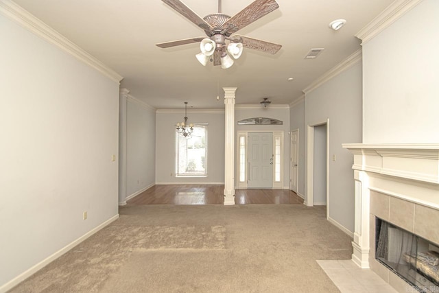 unfurnished living room with light carpet, crown molding, decorative columns, and a tile fireplace