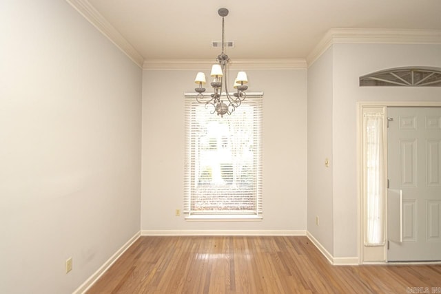 unfurnished room featuring wood-type flooring, a notable chandelier, and crown molding