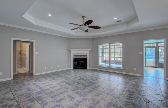 unfurnished living room featuring ornamental molding, ceiling fan, and a tray ceiling