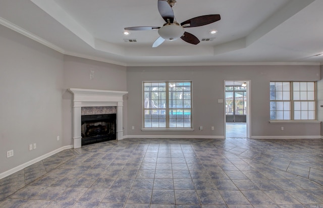 unfurnished living room with a raised ceiling, ceiling fan, and crown molding