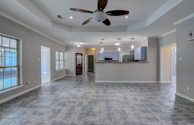 unfurnished living room with a raised ceiling, ceiling fan, and crown molding