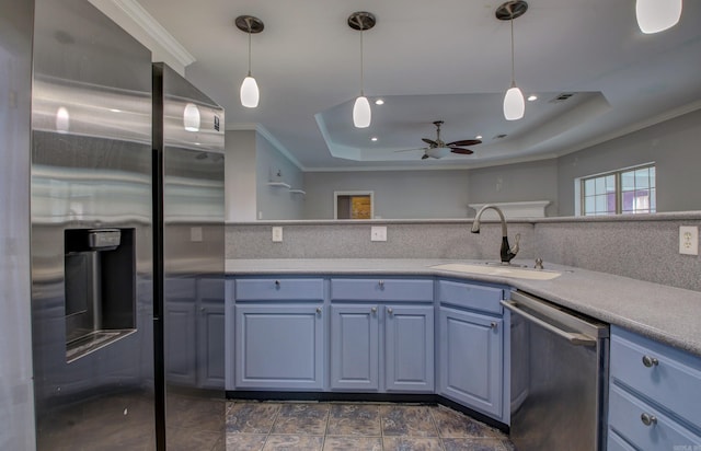 kitchen with crown molding, stainless steel appliances, a raised ceiling, hanging light fixtures, and sink