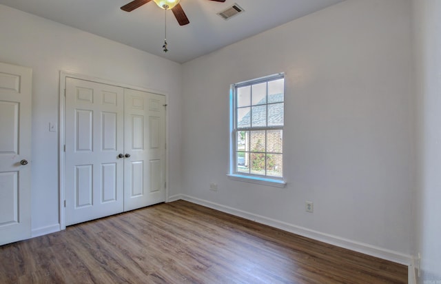 unfurnished bedroom with wood-type flooring, ceiling fan, and a closet