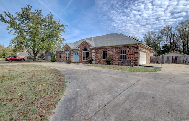 ranch-style house featuring a garage and a front yard