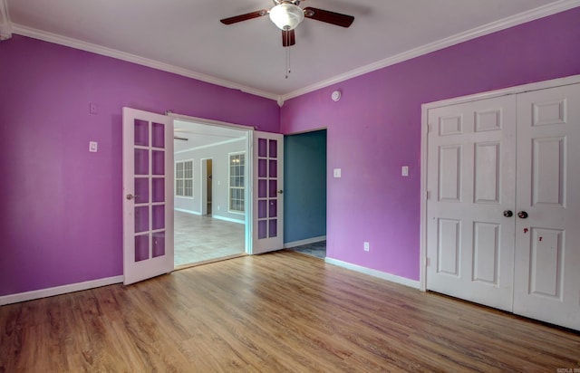 interior space with ceiling fan, wood-type flooring, crown molding, a closet, and french doors