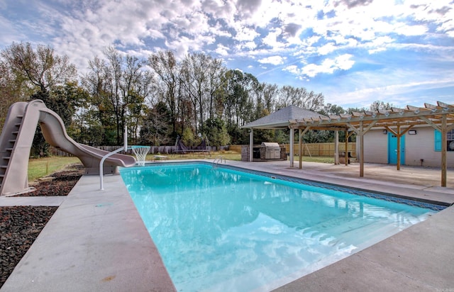 view of pool with a water slide, a patio, and a pergola