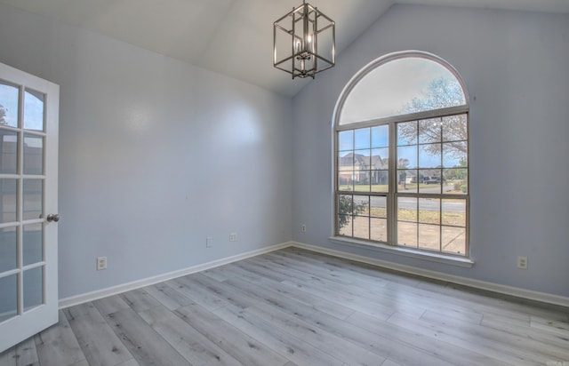 unfurnished room with light hardwood / wood-style flooring, a chandelier, and vaulted ceiling