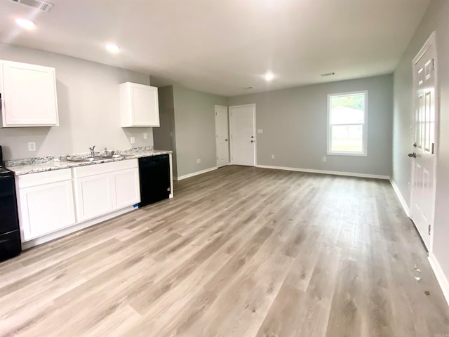 kitchen featuring black appliances, sink, light stone countertops, white cabinetry, and light wood-type flooring