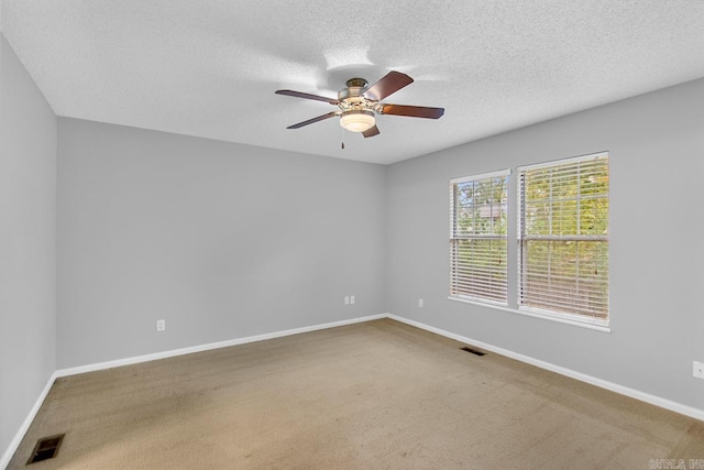 unfurnished room featuring a textured ceiling, ceiling fan, and carpet floors