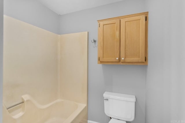 bathroom featuring a tub to relax in and toilet