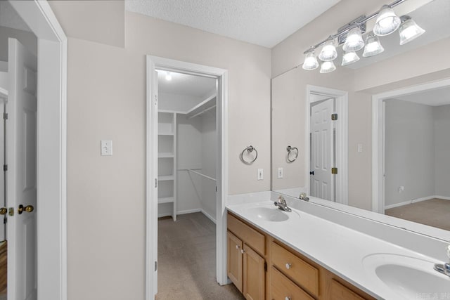 26 Summerwood Cv, Benton, AR 72015 - bathroom featuring double vanity, a textured ceiling, and baseboards