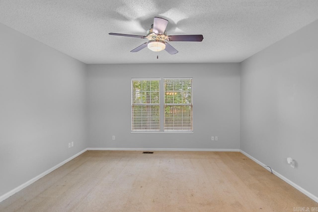 carpeted spare room featuring a textured ceiling and ceiling fan