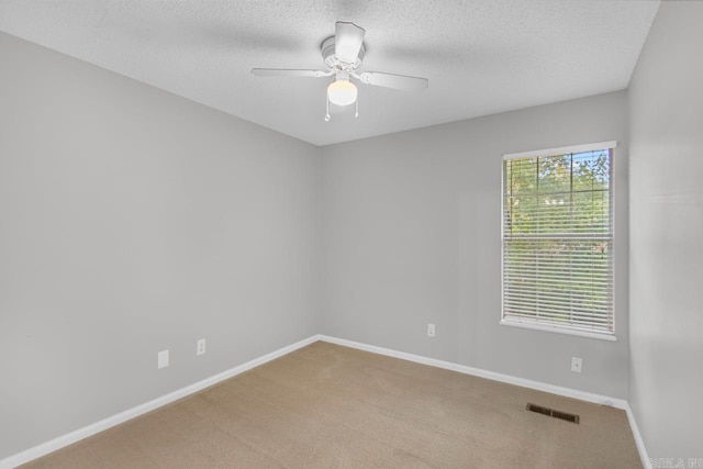 carpeted spare room featuring a textured ceiling and ceiling fan