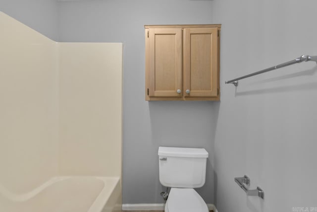 bathroom featuring a tub to relax in and toilet