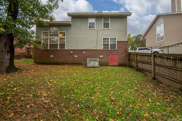 back of house featuring central AC unit and a yard