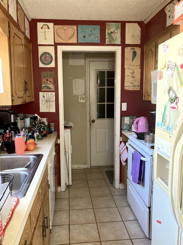 kitchen with light tile patterned flooring, white appliances, sink, and a textured ceiling