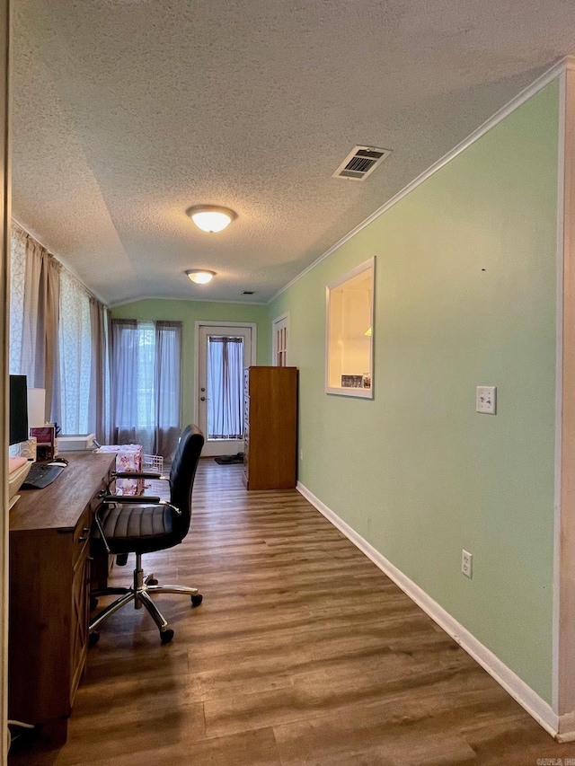 office space with wood finished floors, crown molding, a textured ceiling, baseboards, and lofted ceiling