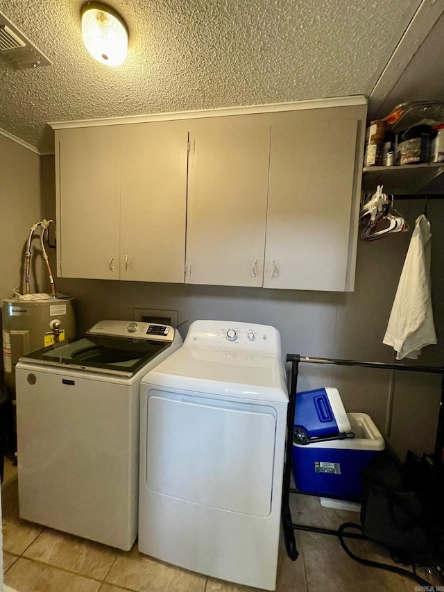 laundry room with washing machine and clothes dryer, a textured ceiling, cabinet space, crown molding, and electric water heater