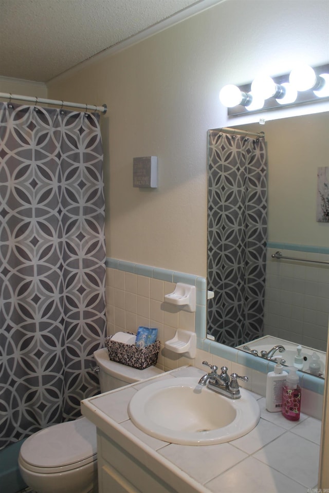 bathroom with tile walls, toilet, vanity, wainscoting, and a shower with curtain