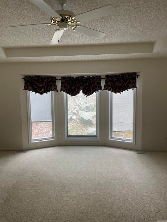 carpeted empty room with a textured ceiling and ceiling fan