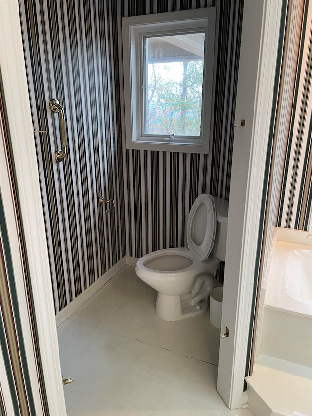 bathroom with toilet and tile patterned floors