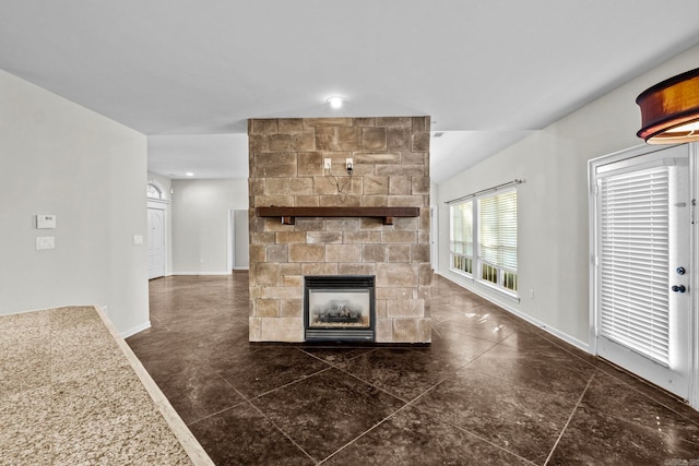 unfurnished living room with a stone fireplace