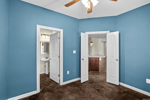 unfurnished bedroom featuring ensuite bathroom, ceiling fan, and sink