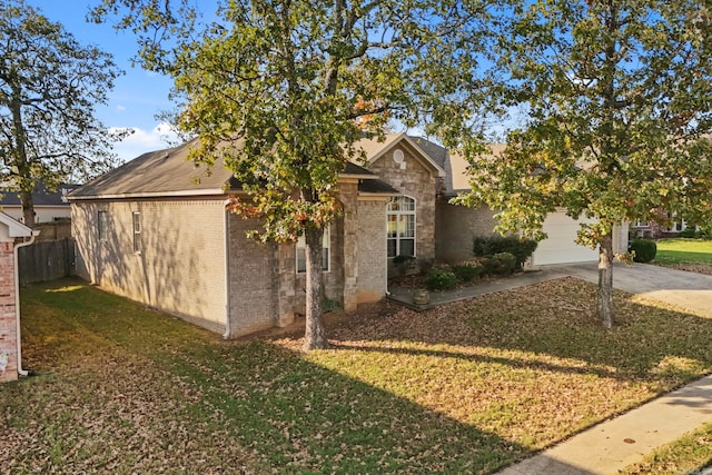 view of property hidden behind natural elements featuring a garage and a front lawn