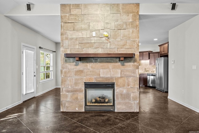 details featuring a fireplace, appliances with stainless steel finishes, and tasteful backsplash