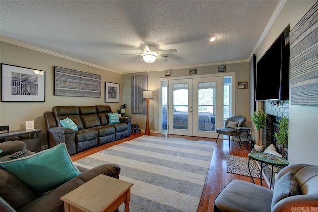 living room with hardwood / wood-style flooring, a textured ceiling, french doors, and ornamental molding