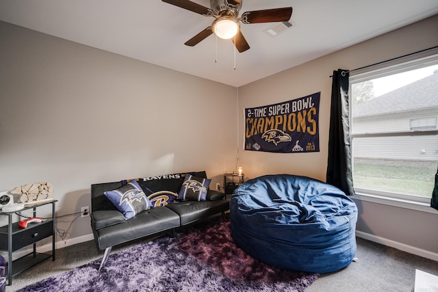 living room with a wealth of natural light, carpet floors, and ceiling fan