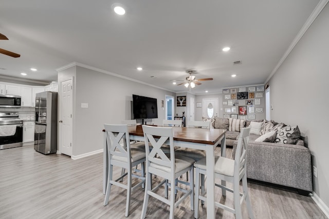 dining space with ornamental molding, ceiling fan, and light hardwood / wood-style flooring