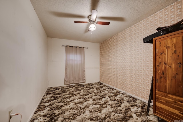 carpeted empty room featuring ceiling fan and a textured ceiling