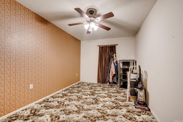 carpeted empty room with a textured ceiling and ceiling fan