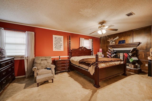 carpeted bedroom featuring a textured ceiling, ceiling fan, and crown molding