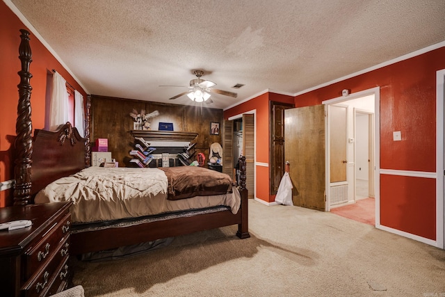 carpeted bedroom with a textured ceiling, ornamental molding, and ceiling fan