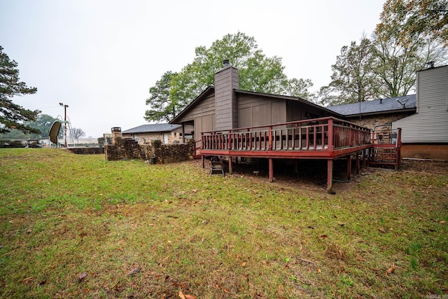 back of house featuring a lawn and a deck