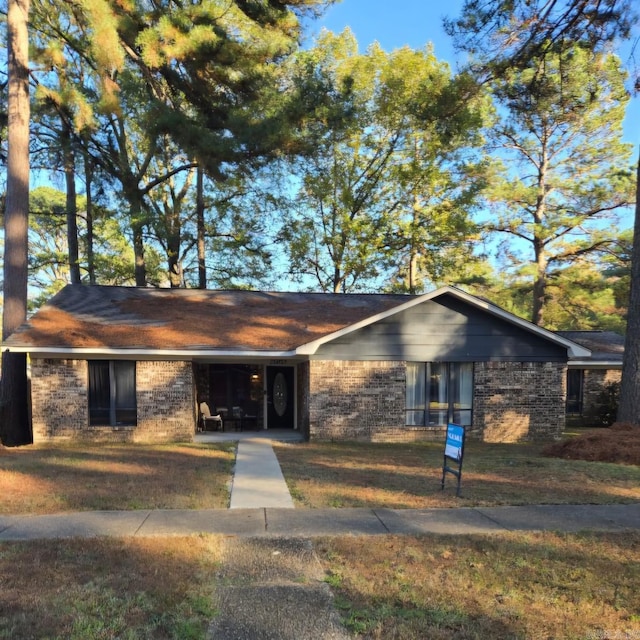 ranch-style house featuring a garage and a front lawn