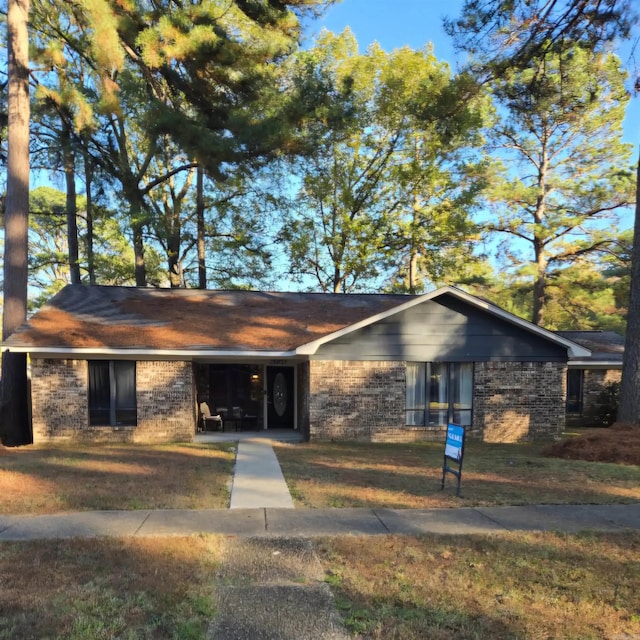 ranch-style house featuring a front yard and a garage