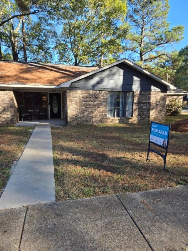 view of front of home with brick siding and a front yard